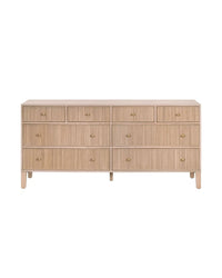 A beige oak dresser with multiple drawers and gold handles, presented in a frontal view against a white background.