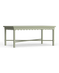 A rectangular outdoor coffee table with scalloped edge details, painted in a sage green color, with visible wooden frame and supporting legs.