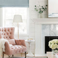 White stonecast side table next to a pink velvet chair