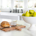 White pedestal bowl filled with pears on kitchen counter