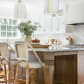 Kitchen with island featuring two large white and brass pendant lights