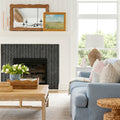 Bright living room with black fireplace and blue couch resting on beige and pale blue rug