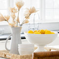 White pedestal bowl filled with lemons on kitchen counter