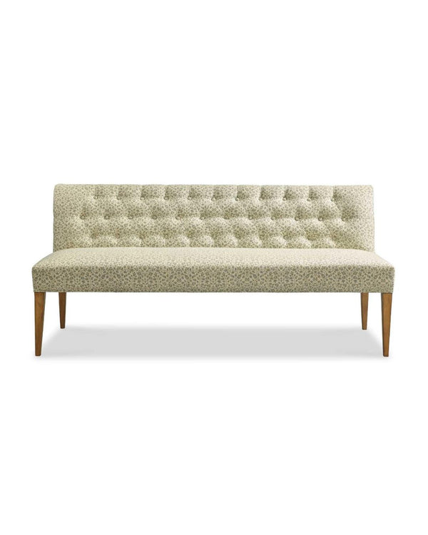 An upholstered bench with a tufted back, featuring a moss green fabric and a driftwood finish wood frame.