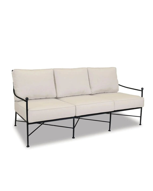 An Emmeline Collection sofa with a wrought iron frame and beige cushions, designed for outdoor use.