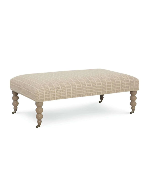A beige upholstered ottoman with a geometric pattern on the fabric, featuring vintage-style wooden legs on a white background.
