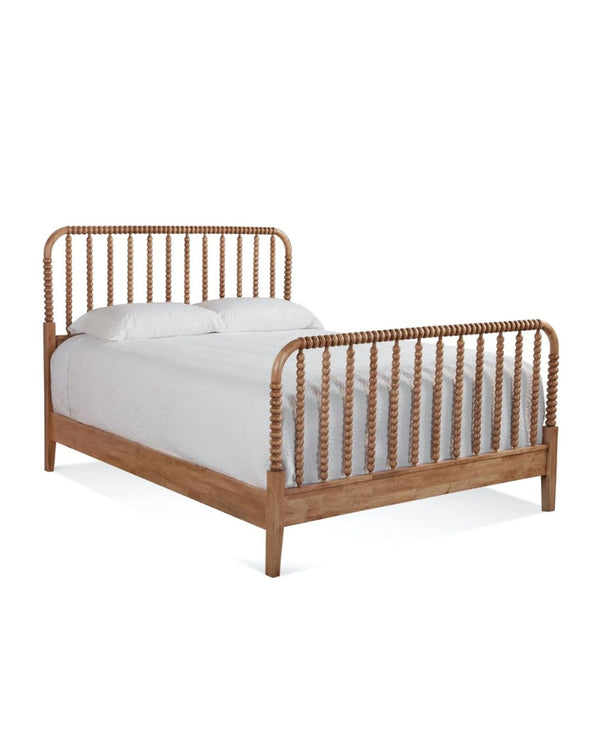 A wooden bed frame with spindle details on the headboard and footboard, dressed with a white comforter.