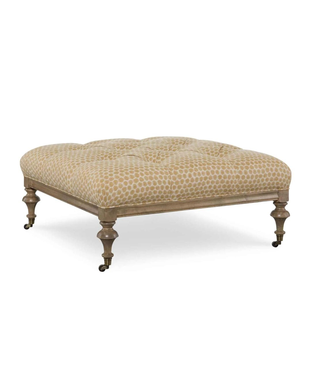 An upholstered square ottoman with a geometric pattern on the fabric, featuring wooden legs and casters.
