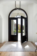 Beige and pale blue rug in foyer with arched black door