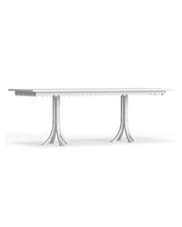 A white rectangular Riviera dining table with scalloped edge details and a metallic structure, set against a plain background.