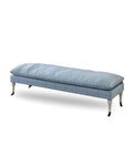 An upholstered bench with blue fabric, turned leg details, and metal casters.
