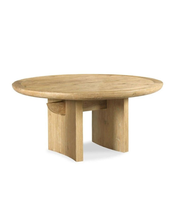 A rounded, oak wood dining table with a curved slab leg and a central beam, inspired by a Japanese Torii Gate.
