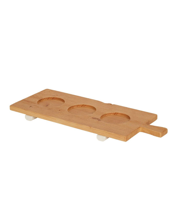 A wooden tray with three indentations used to hold pinch pots, with cream-colored feet for elevation.