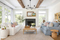 Bright living room with one blue couch and one whote couch resting on beige and pale blue rug