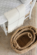 Basket trio resting on 100% wool rug with antiqued warm tones