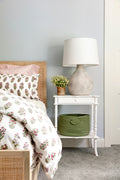 Bed frame designed with a natural mango frame and woven cane inset in bedroom with floral duvet