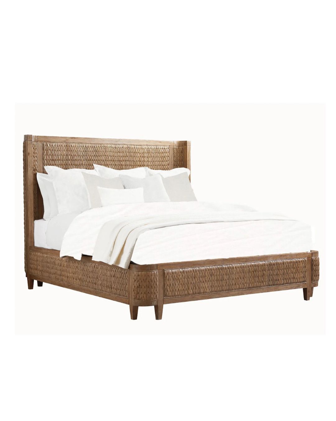 A woven bed frame with a white mattress and pillows on it. The bed has a shelter design with a headboard and footboard that curve inward.