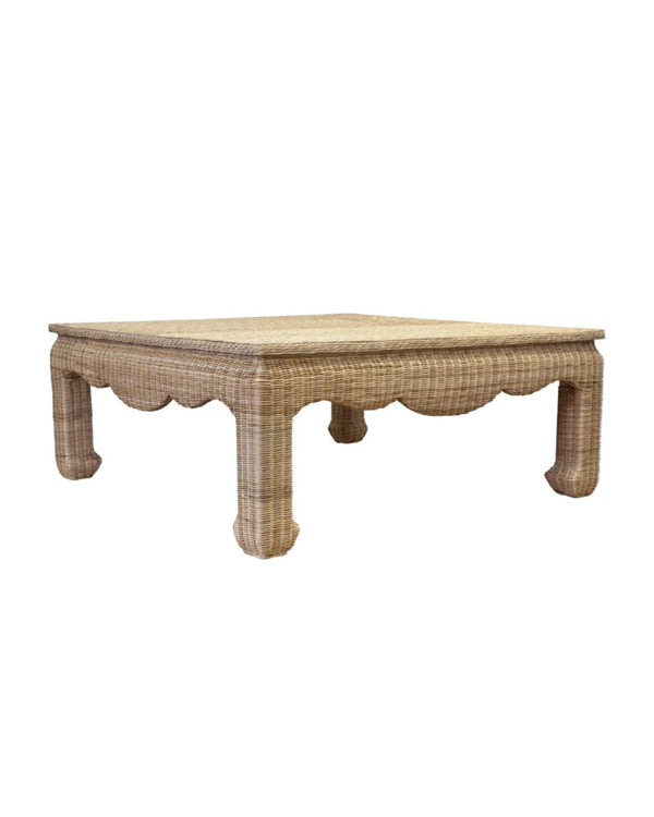 A square-shaped wicker coffee table with scalloped edges in a brown color.